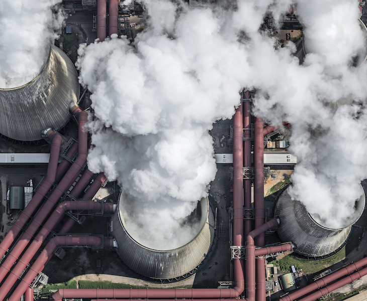 Steam coming out of cooling towers of coal-fired power station, aerial view